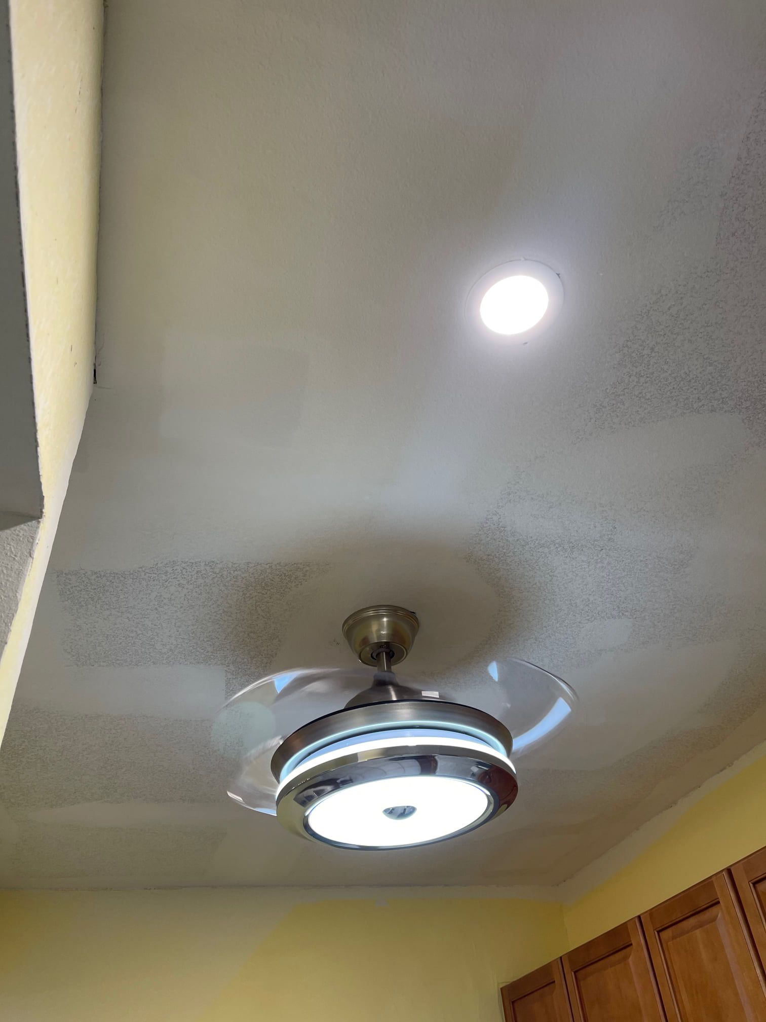 A ceiling fan with a light attached to it is hanging from the ceiling of a room.