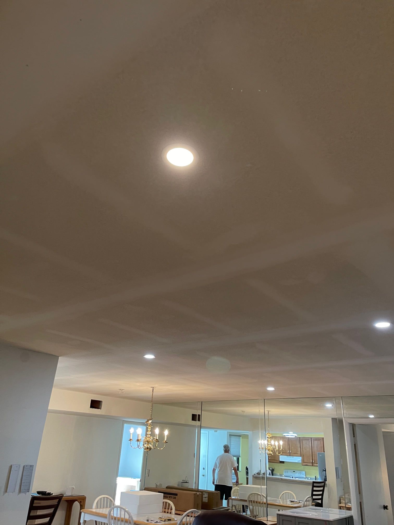 A man is standing in a living room with a light on the ceiling.