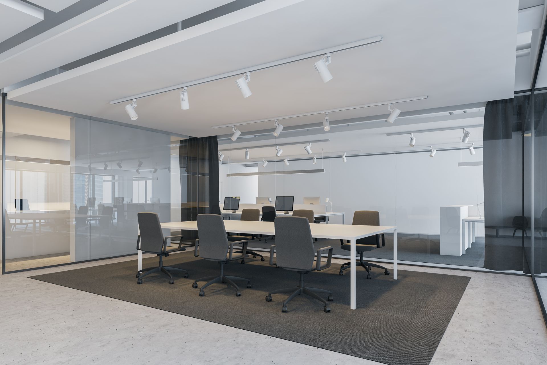 Modern conference room with a long table, black chairs, and track lighting in a glass-walled office