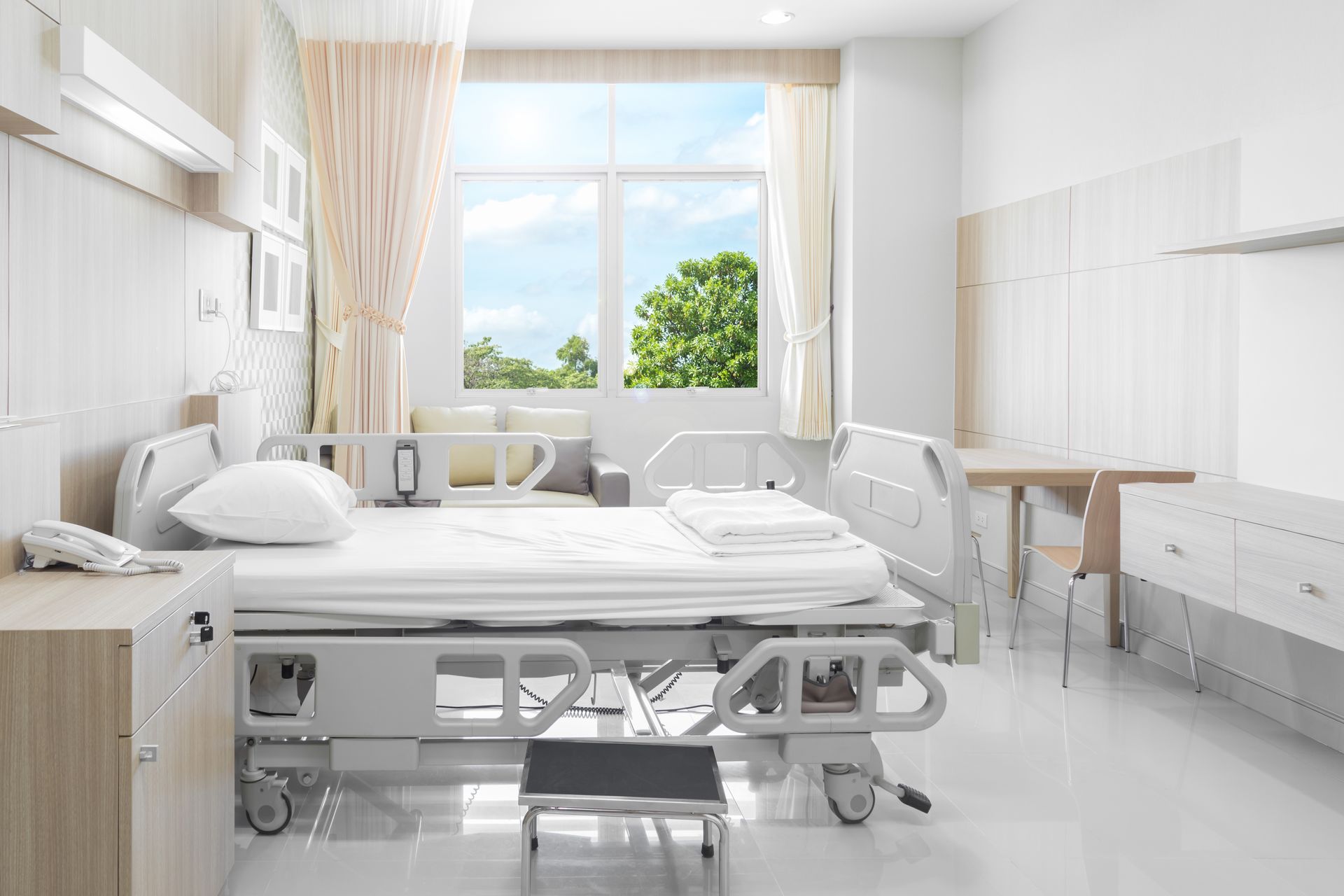 Bright hospital room with an empty bed.