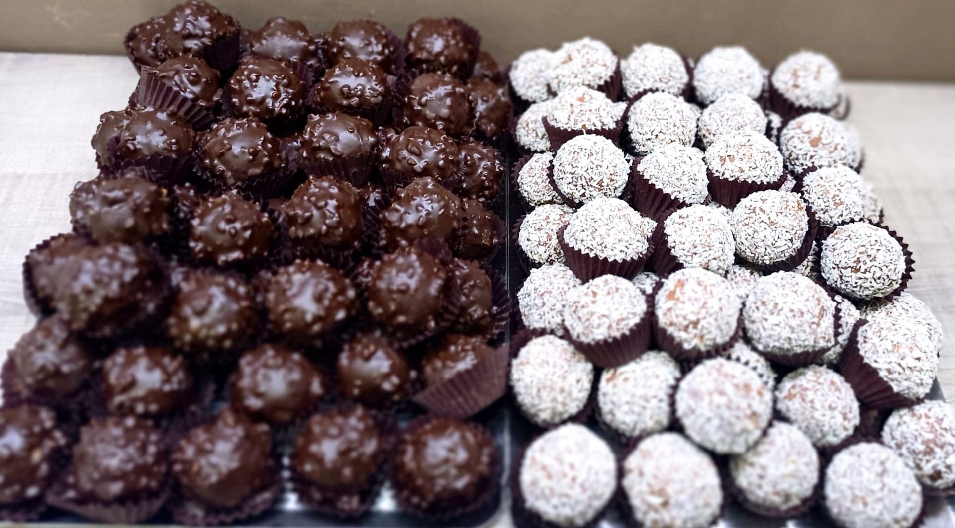 Vassoio di tartufi ricoperti di cioccolato e cocco bianco.