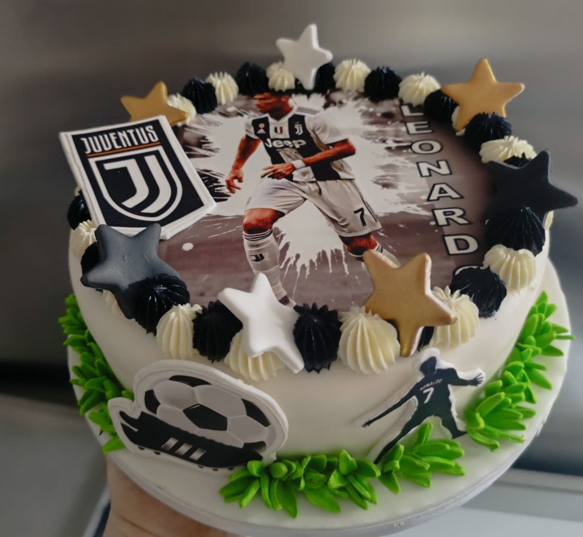 Torta a tema calcistico con un giocatore della Juventus, il logo della squadra e decorazioni a forma di stella.