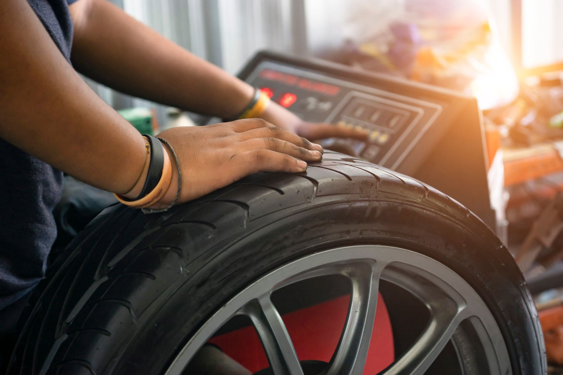 A man working on a tire in a garage, demonstrating tire replacement skills with tools nearby.