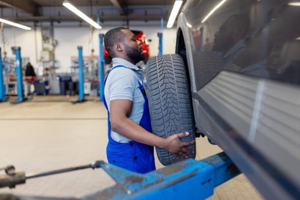 A mechanic performing a tire replacement, showcasing tools and equipment used for the service.