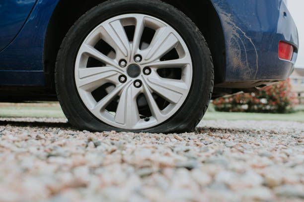 Closeup view of a car’s wheel with a flat tire.