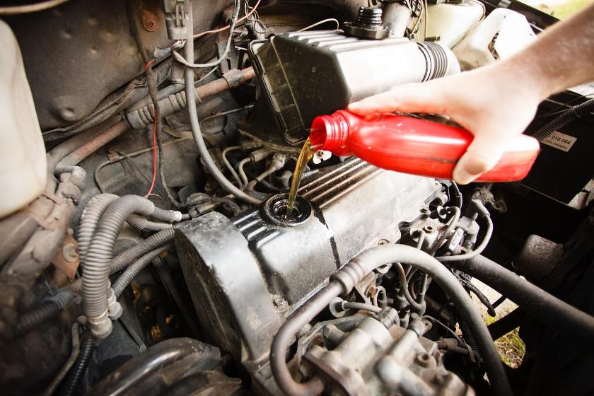 Auto Service — Mechanic Pouring Oil to Engine in Durham, NC