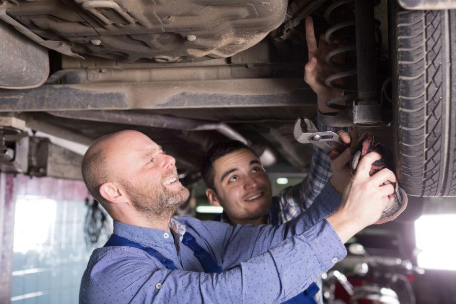 Auto Body Shop Near Me — Two Man Fixing Car Tire Leak in Durham, NC