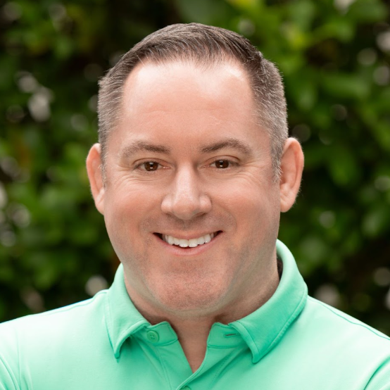 A man in a green shirt is smiling for the camera.