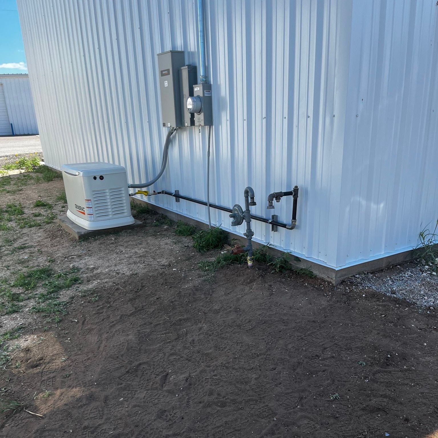 A white building with a generator attached to the side of it.