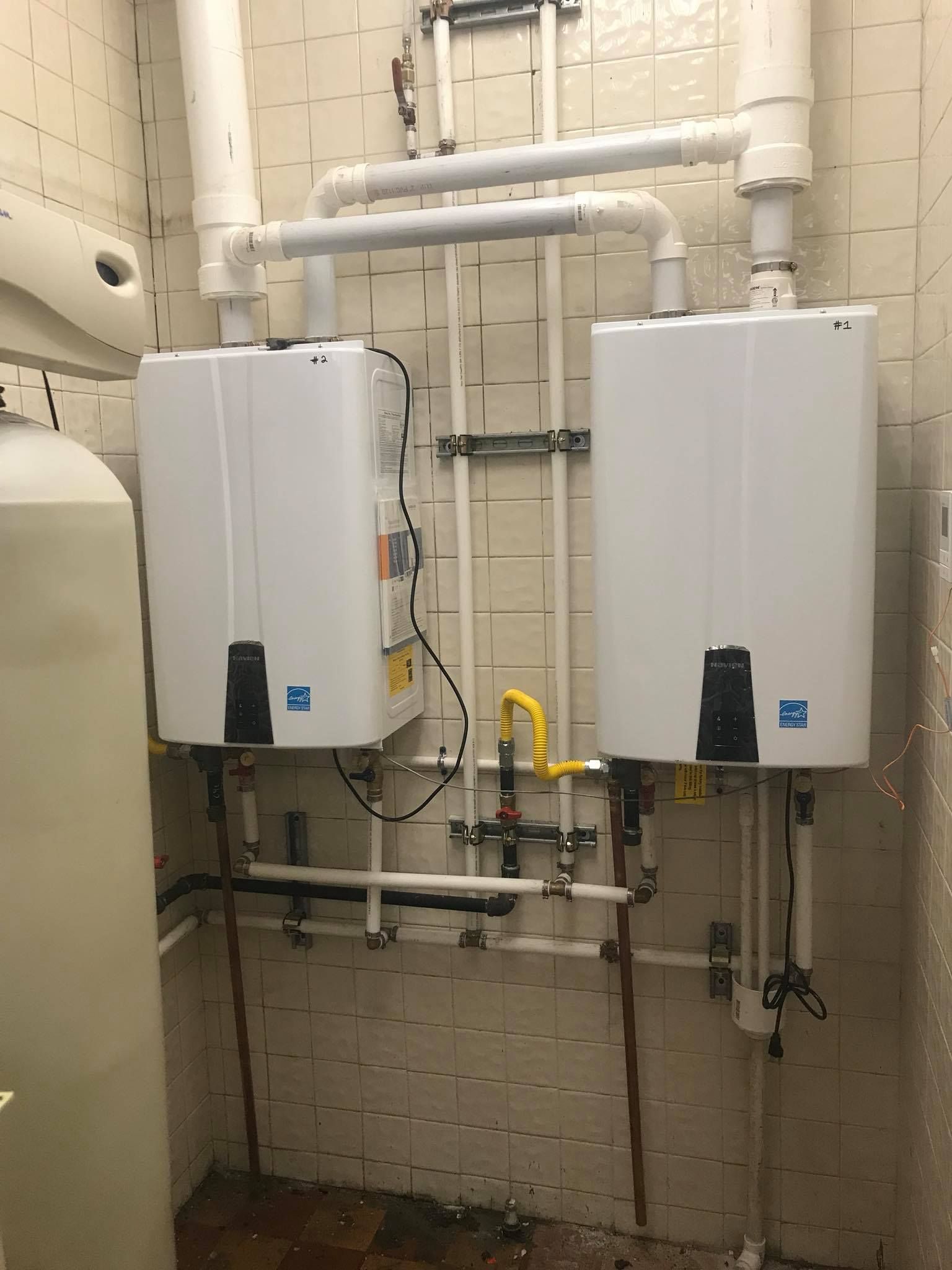 Two water heaters are sitting next to each other in a room.
