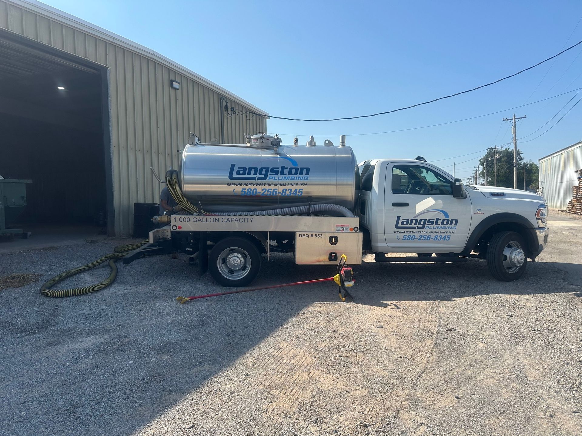 A large tanker truck is parked in front of a building.