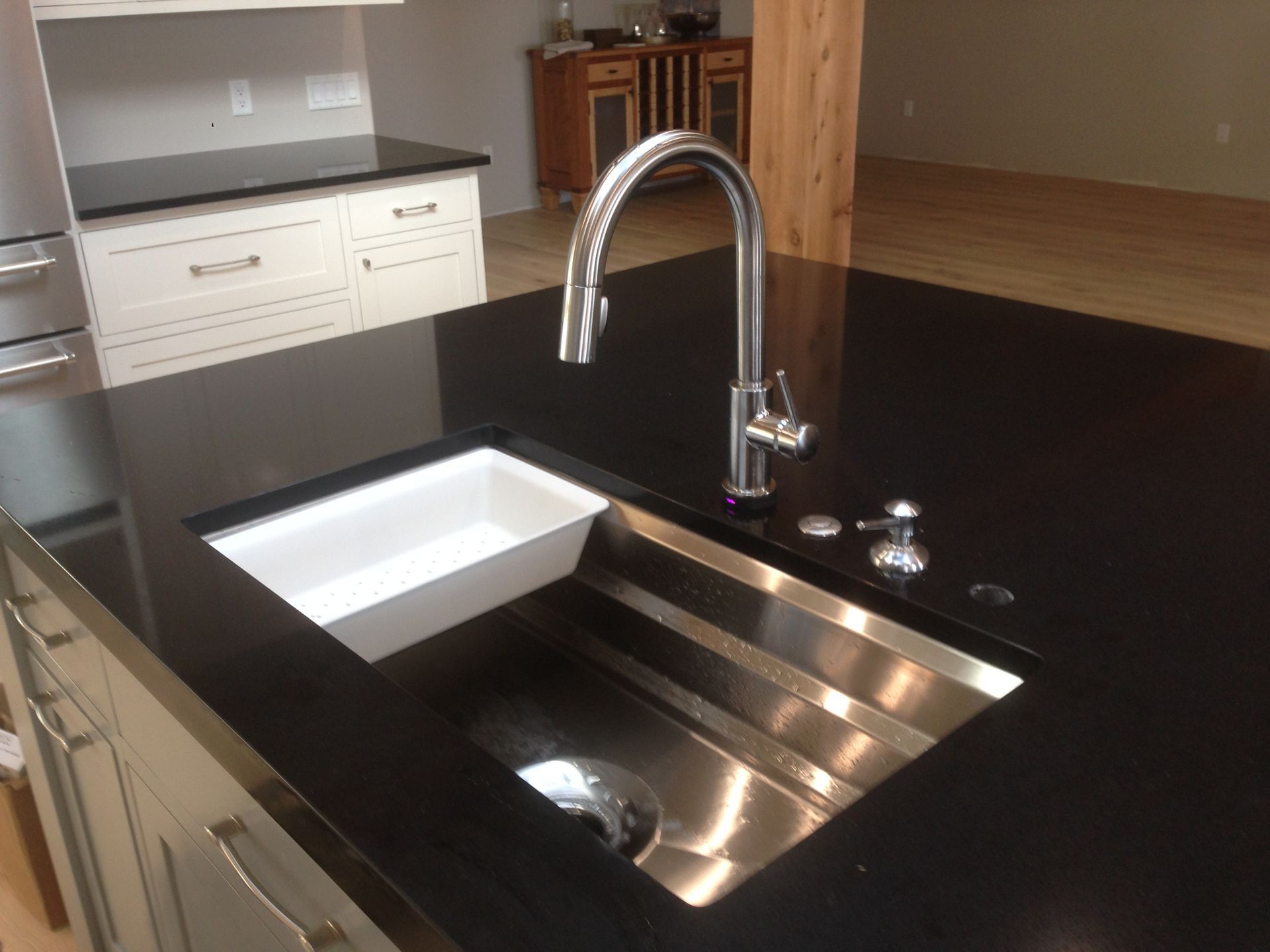 A kitchen with a stainless steel sink and faucet