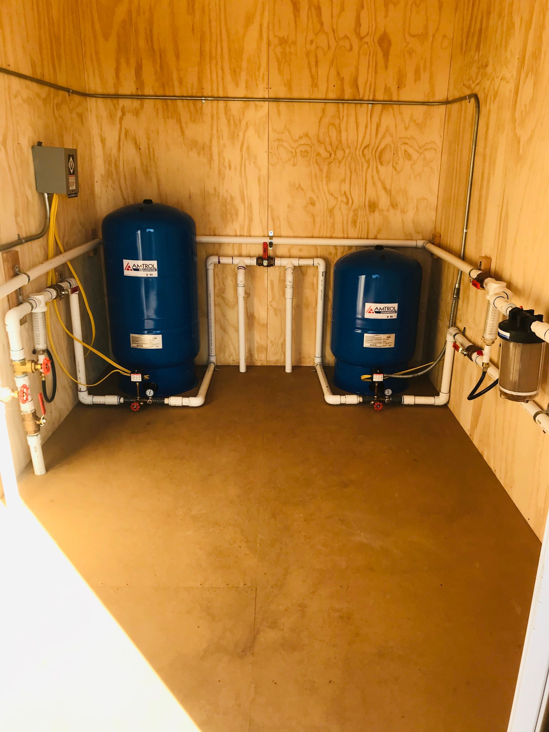 Two water tanks are sitting next to each other in a room.