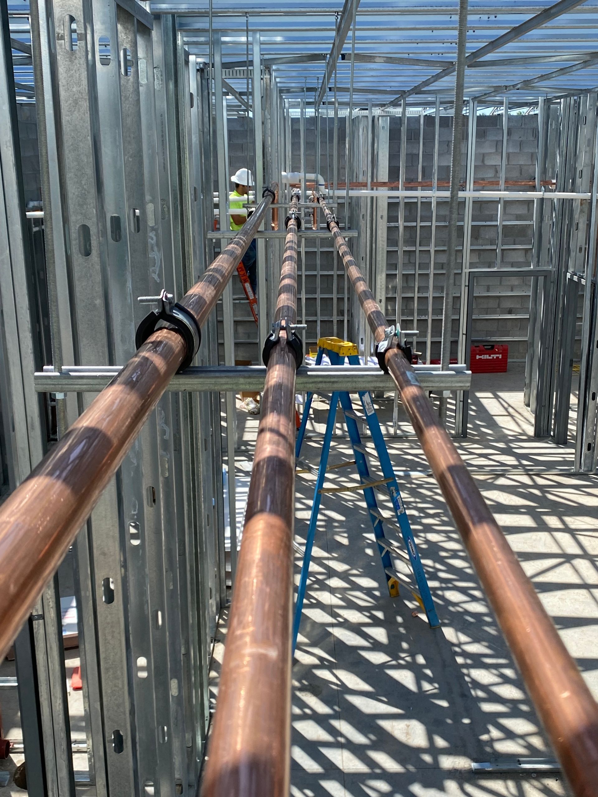 Copper pipes are being installed in a building under construction