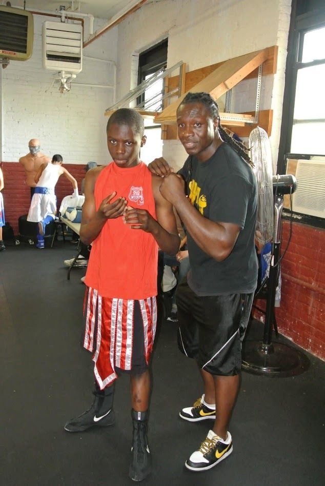 Two boxers are standing next to each other in a gym