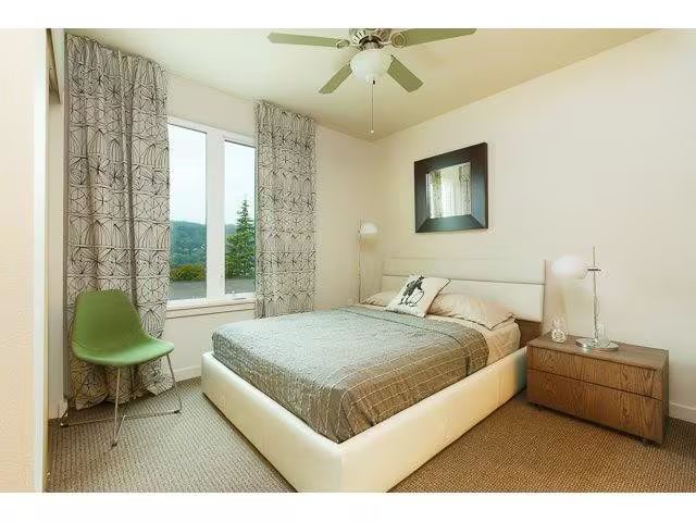 A bedroom with a large bed and a ceiling fan