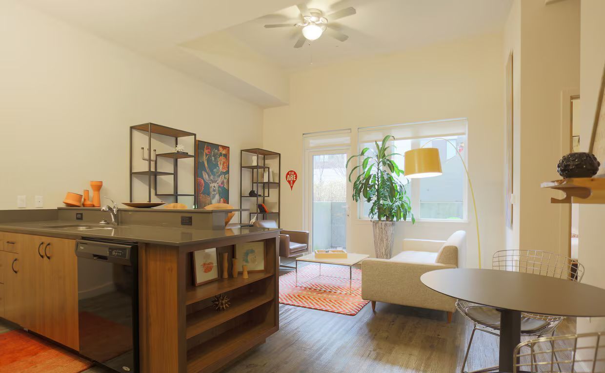 A living room with a table and chairs and a ceiling fan
