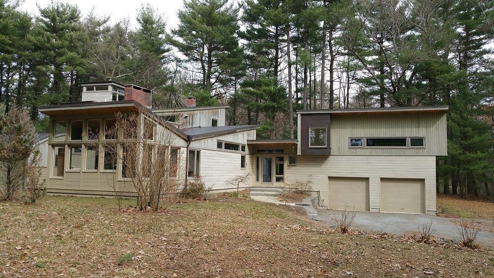 A large house is sitting in the middle of a forest.
