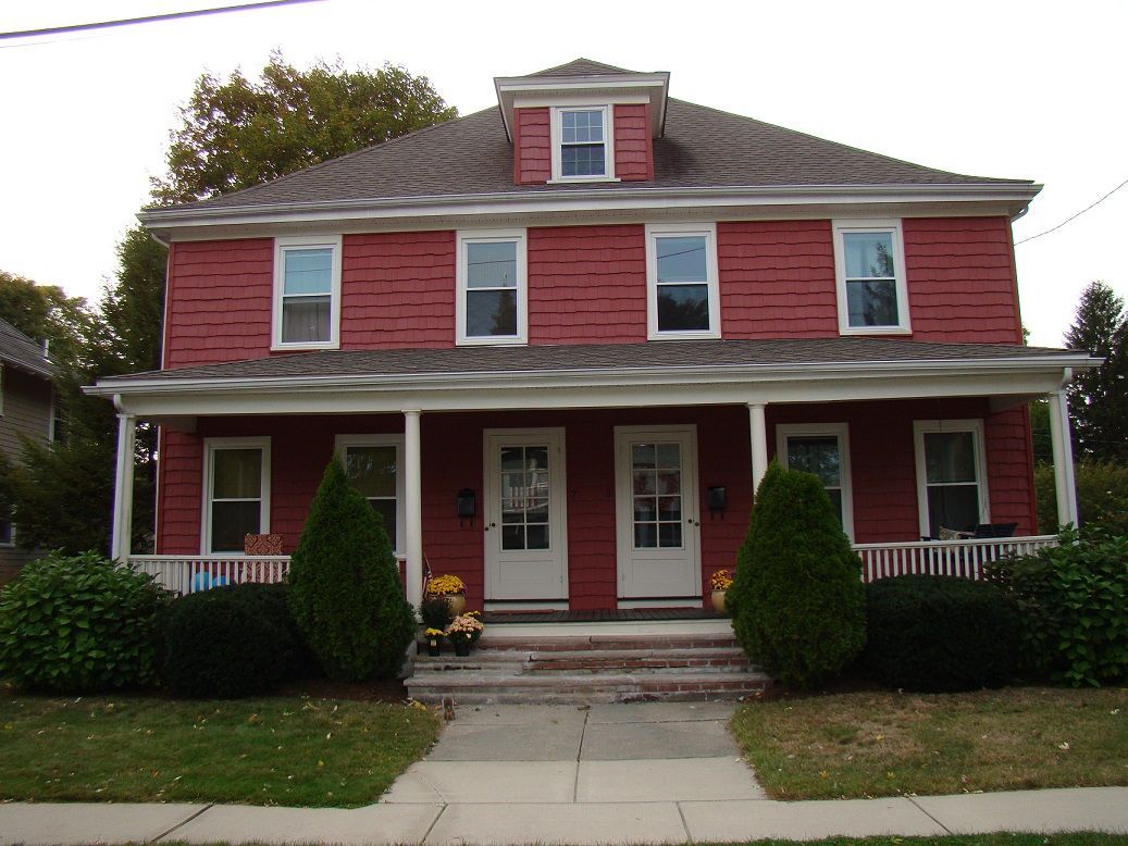 A red house with white trim and a porch