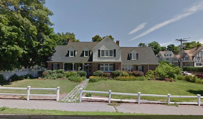 A large house with a white fence in front of it
