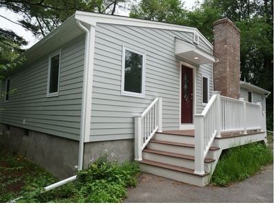 A white house with a red door and stairs