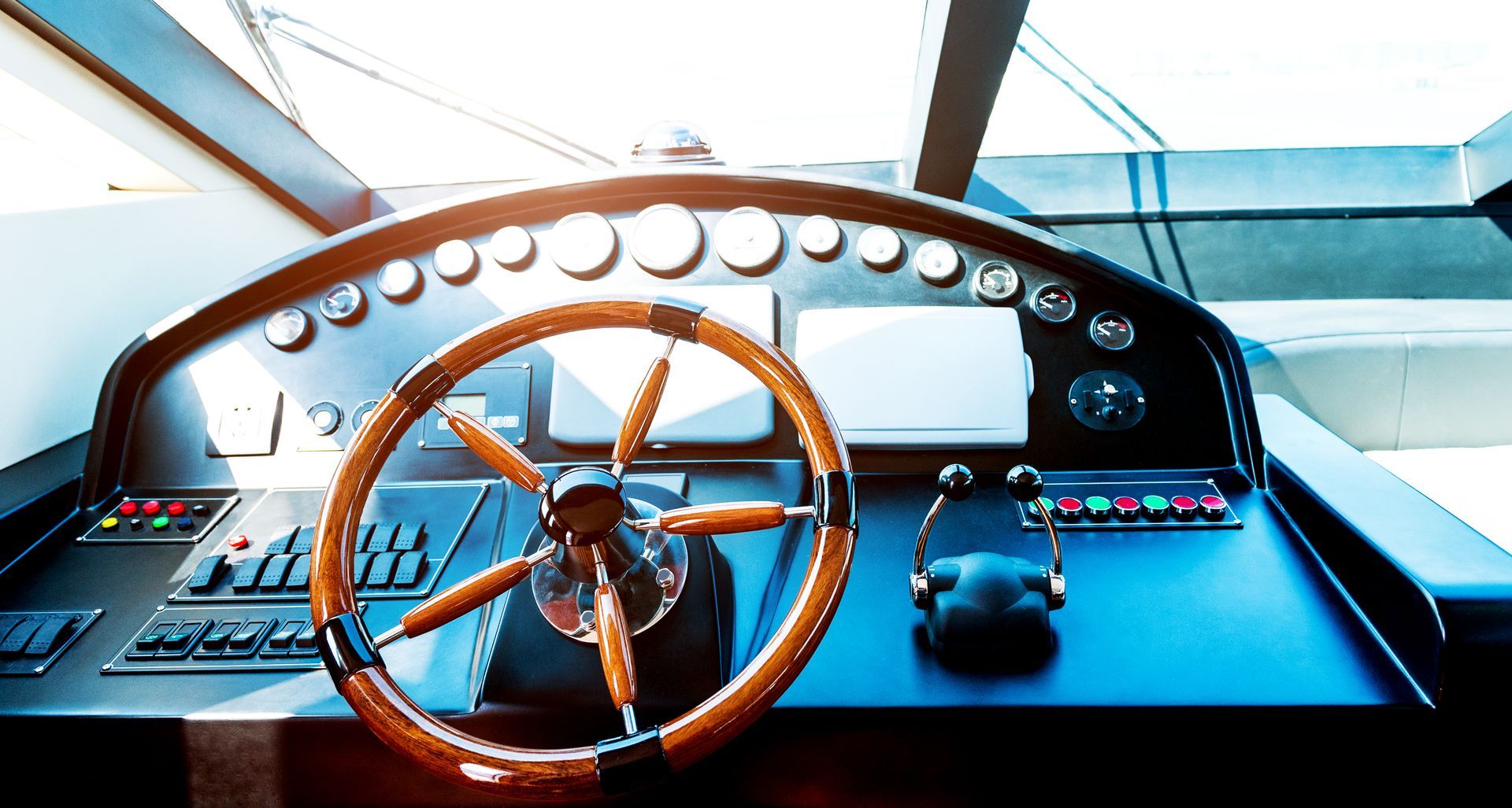 Wooden ship wheel with control panel on a boat.