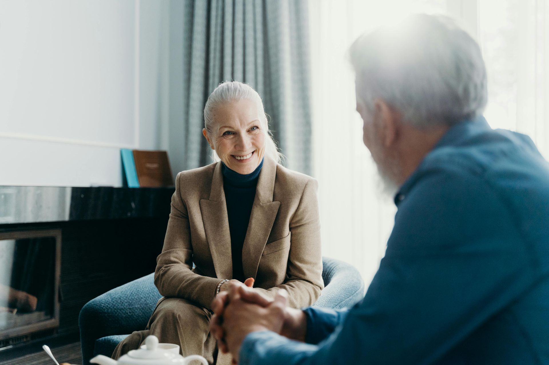 A man and a woman are sitting at a table talking to each other.