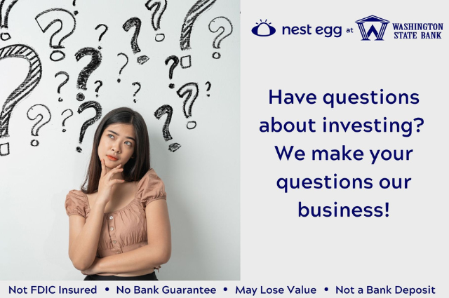 A woman is standing in front of a wall with question marks drawn on it.