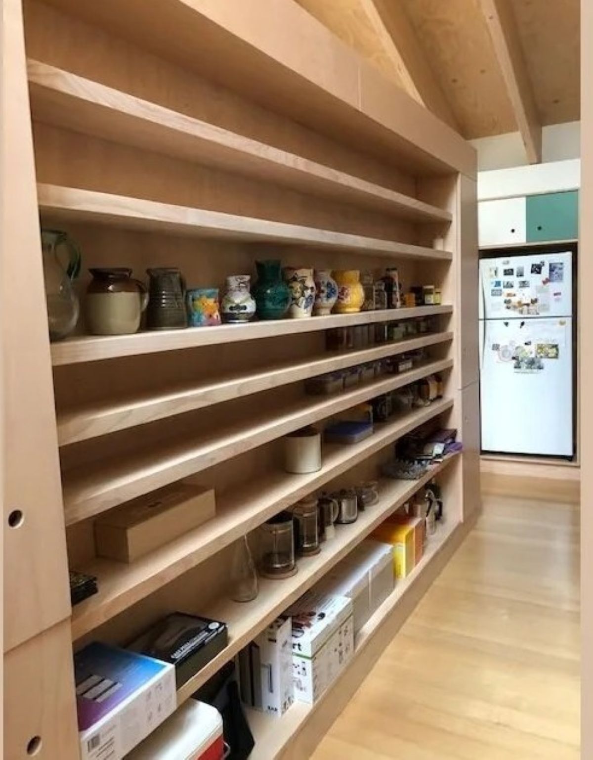 Light Wood Shelving Unit Filled with Items — On The Rise Builders in Noosa, QLD