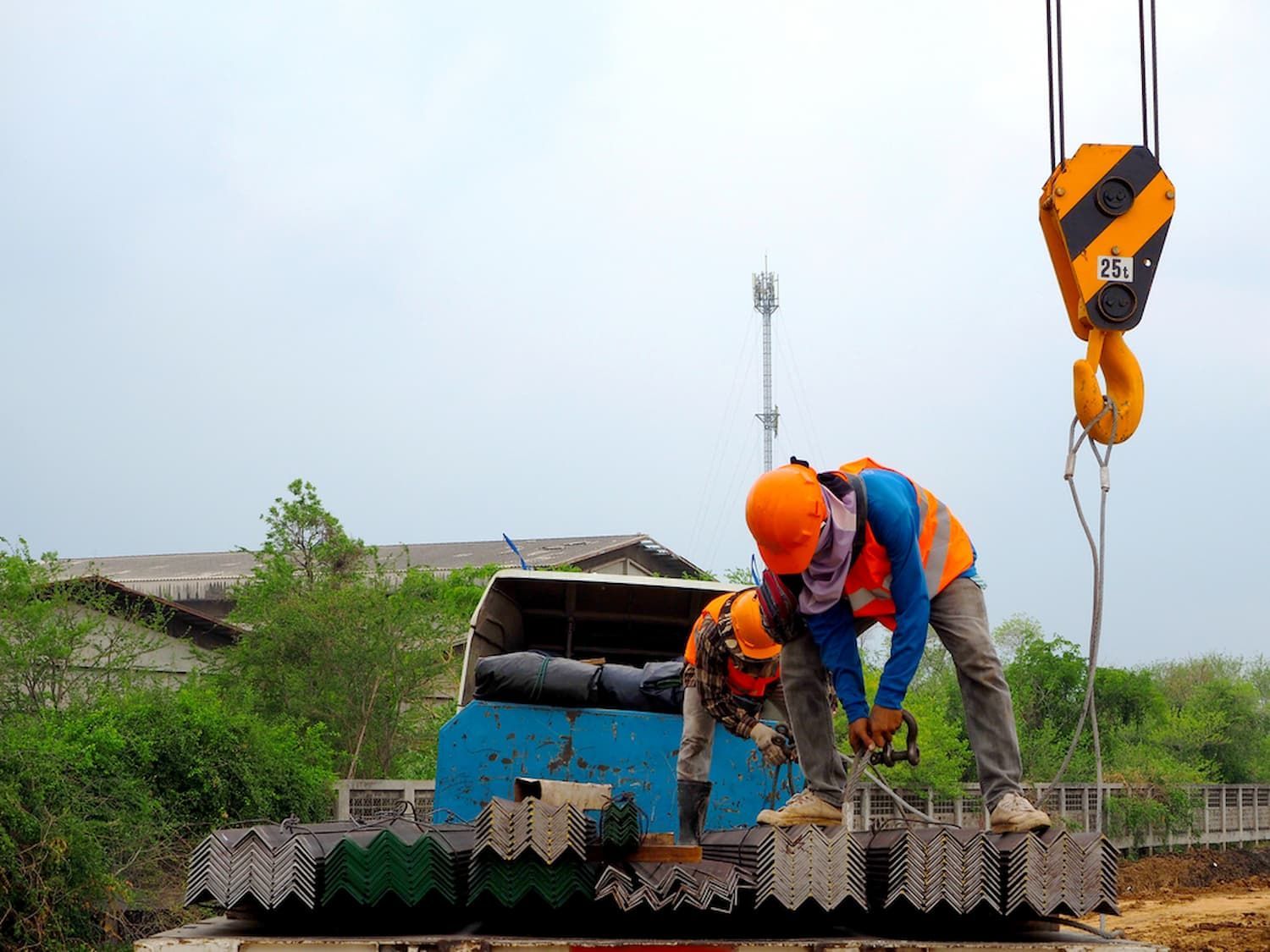 Two Construction Workers Are Working on A Truck Being Lifted by A Crane — D & S Crane Hire & Rigging In Gympie, QLD