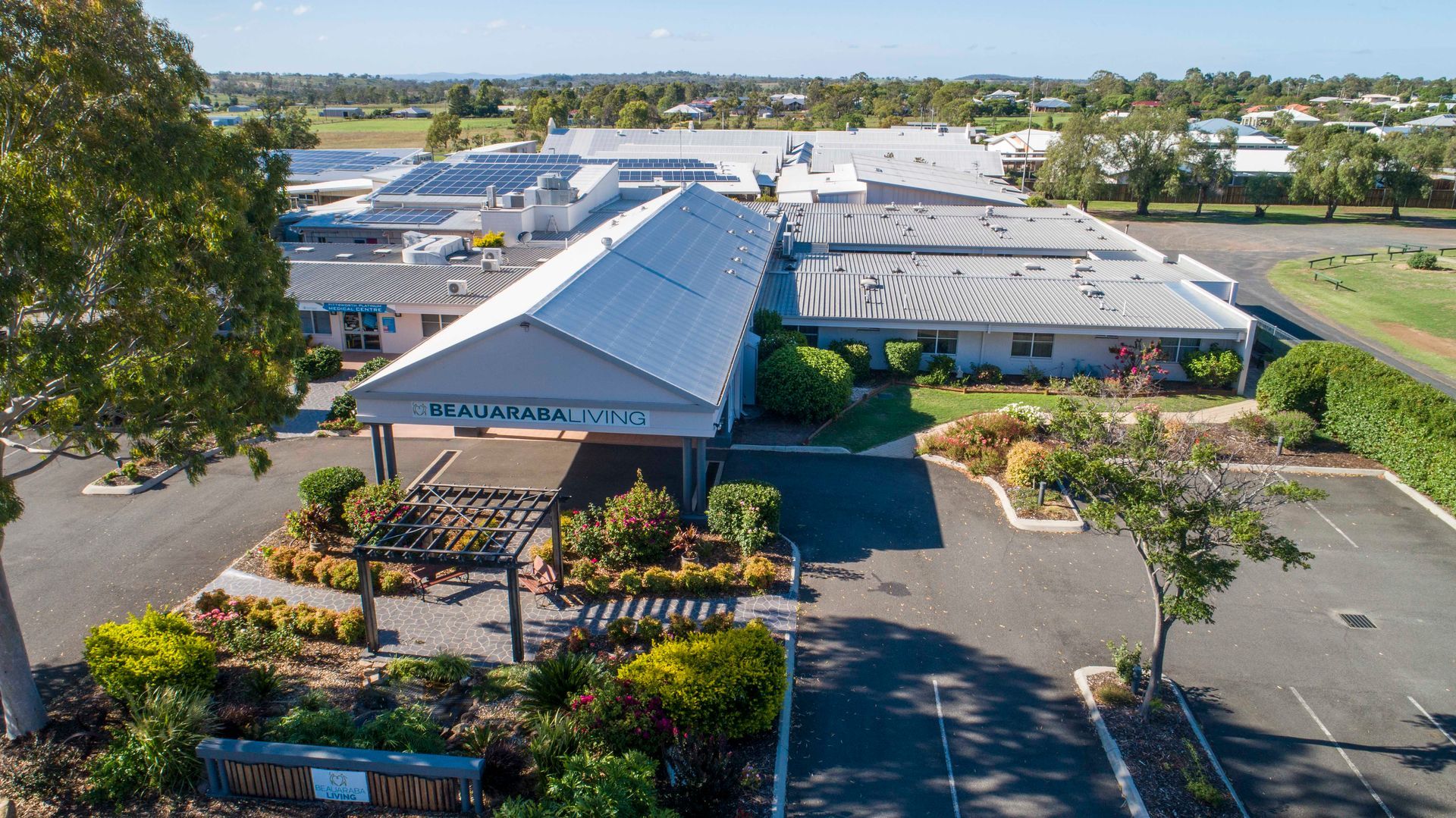 The aerial picture of the Beauaraba Living building surrounded by flowers and bushes.