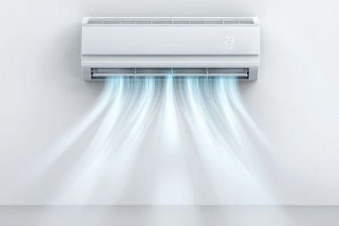 Wall-mounted white air conditioner blowing cool blue air into a room