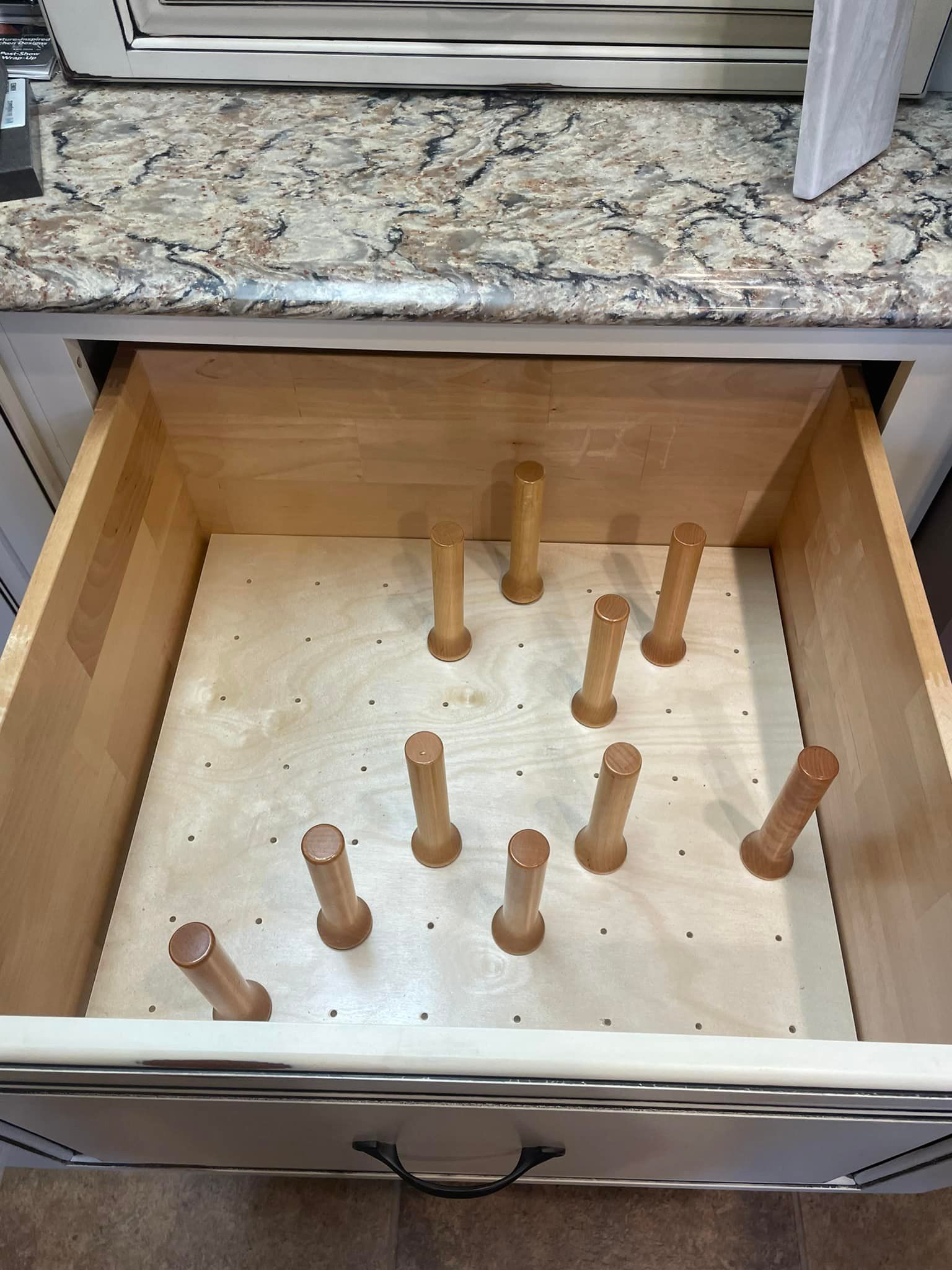 A wooden drawer filled with wooden sticks on a counter.