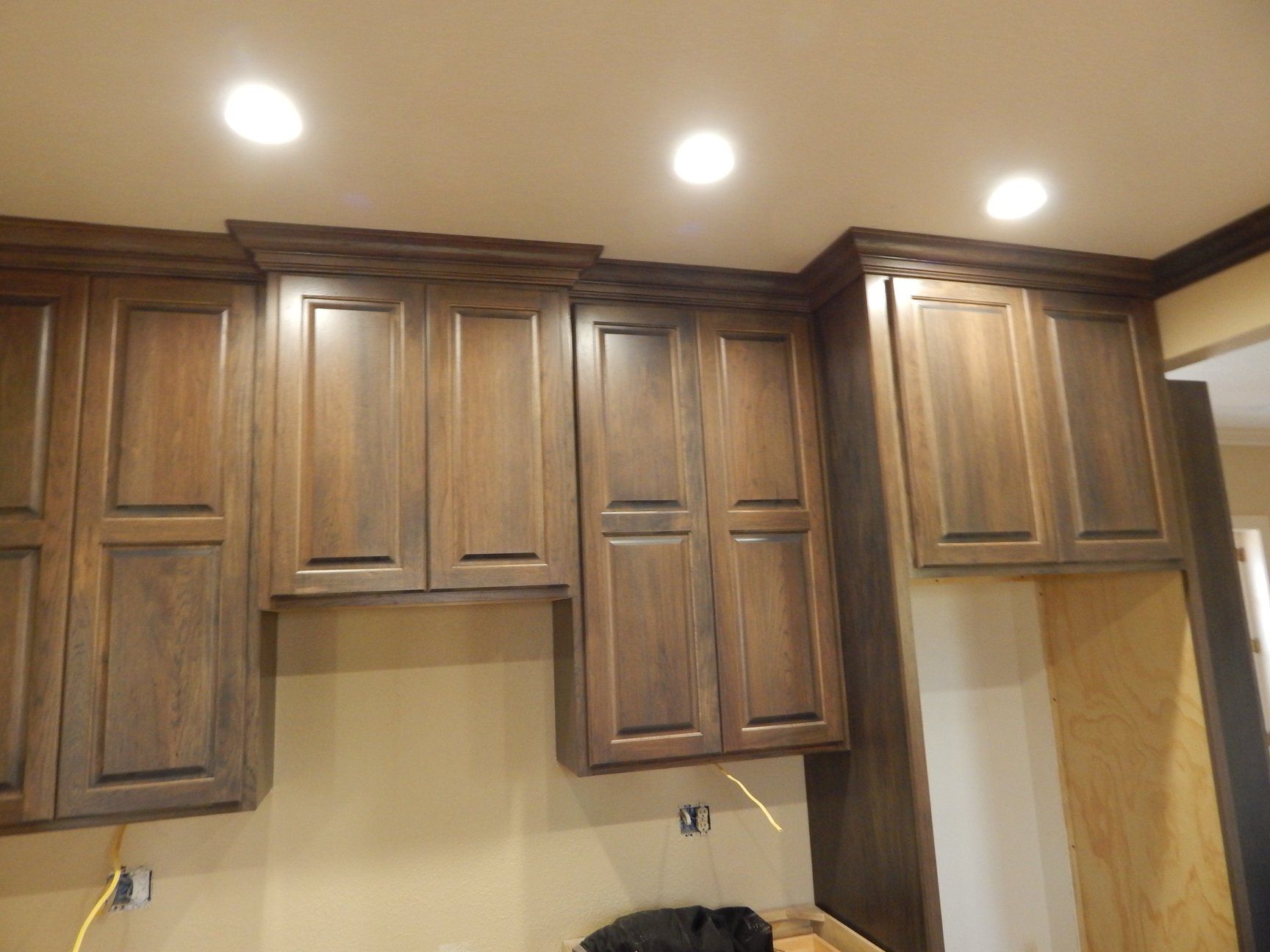 A kitchen with wooden cabinets and a ceiling light