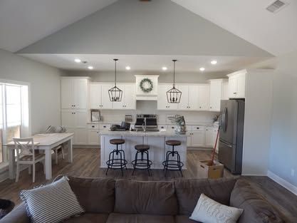 A living room with a couch and a kitchen in the background.