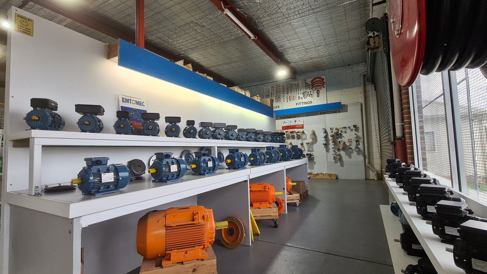 A row of blue electric motors sitting on top of a shelf.
