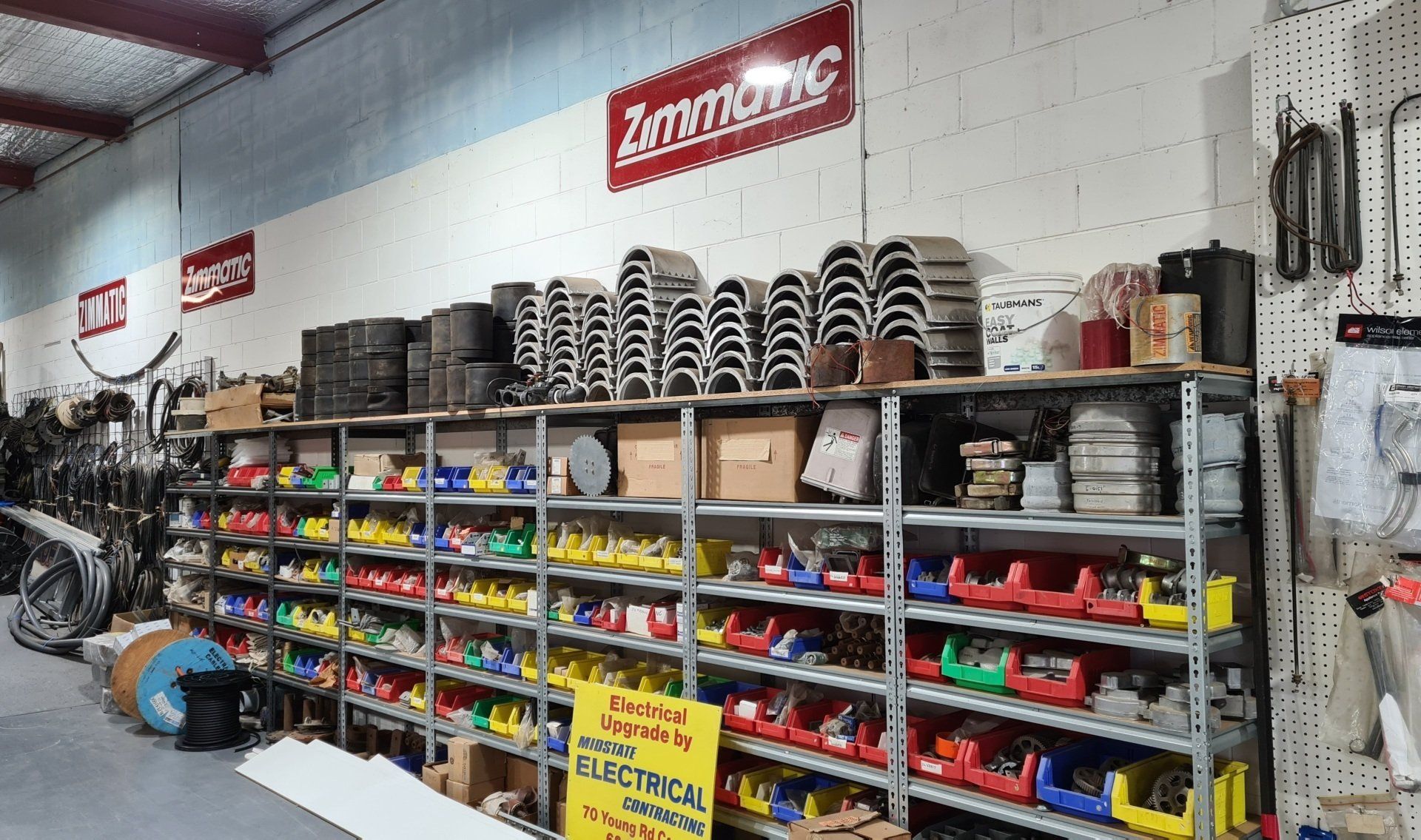 A warehouse filled with lots of electrical parts and a sign that says zimmatic.