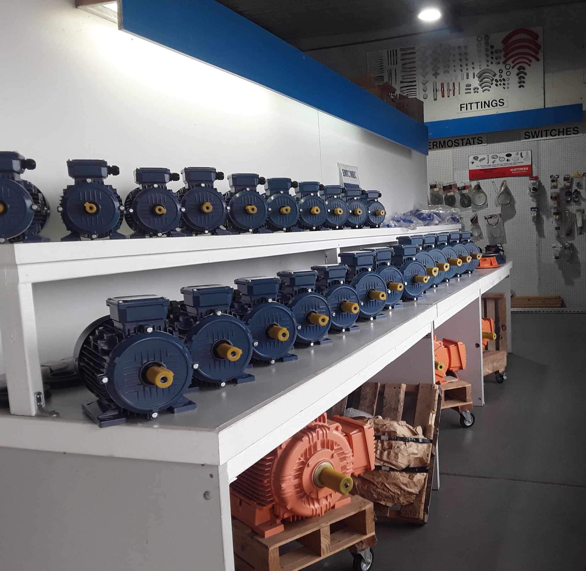 a row of motors lined up on shelves in a store