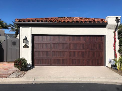 A white house with a brown garage door