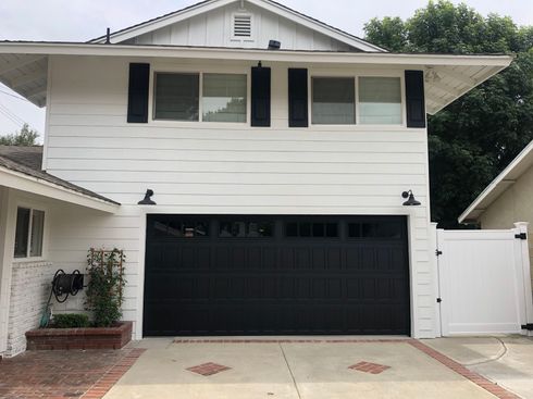 A white house with a black garage door