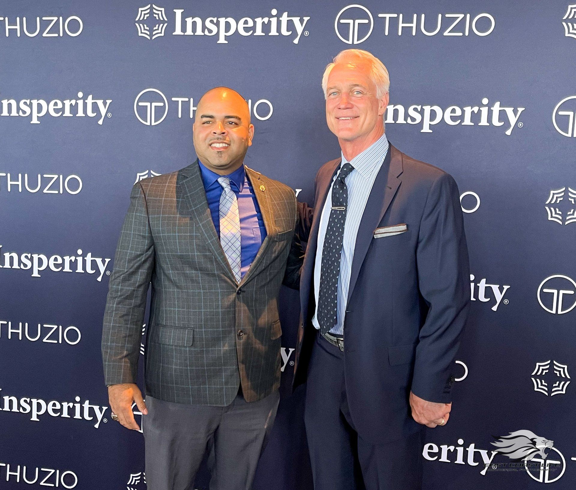Two men standing in front of a wall that says insperity