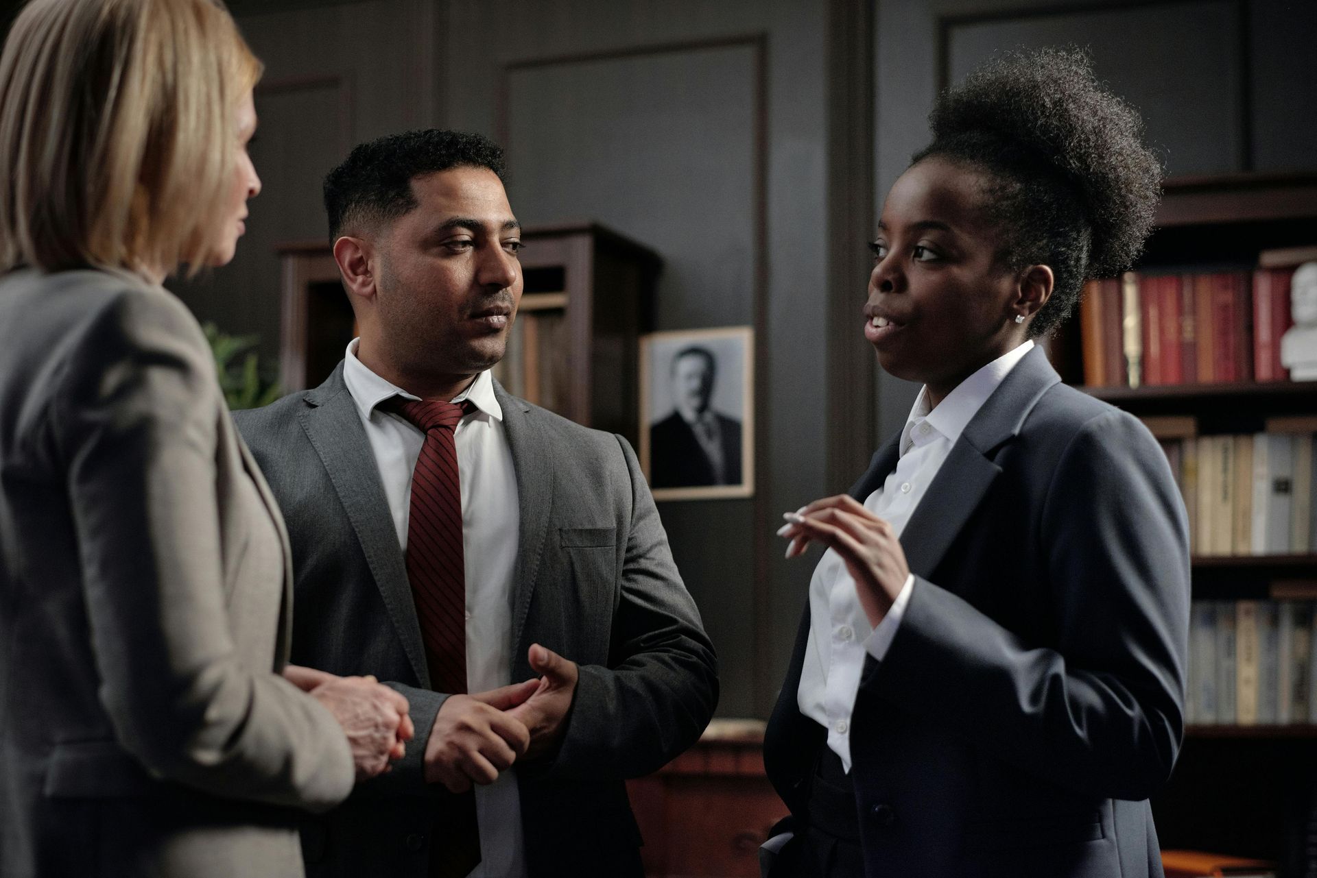 A group of business people are talking to each other in an office.