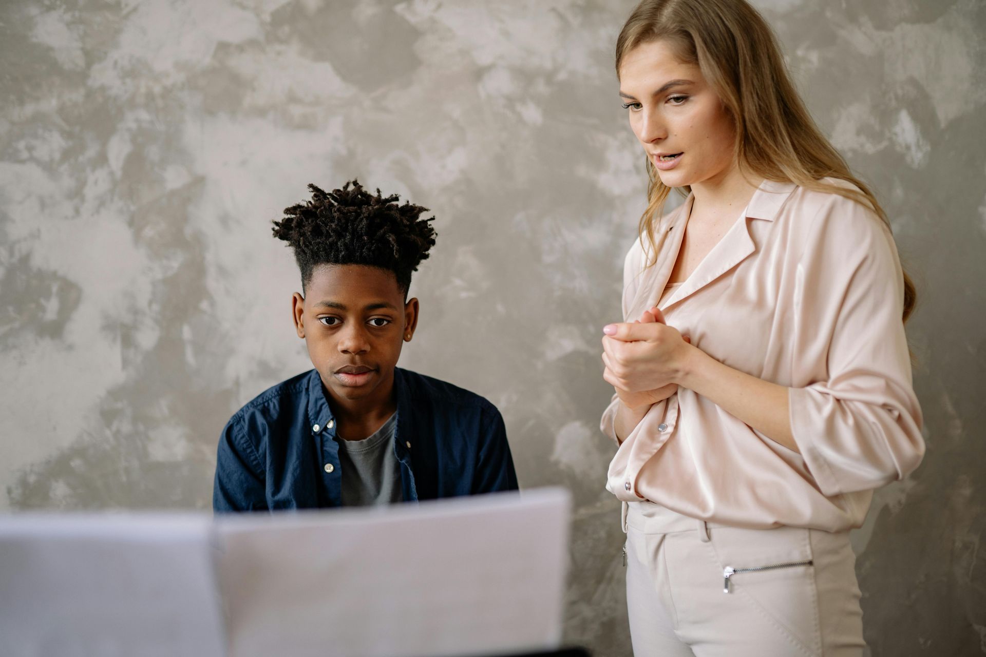 A man and a woman are looking at a laptop computer.