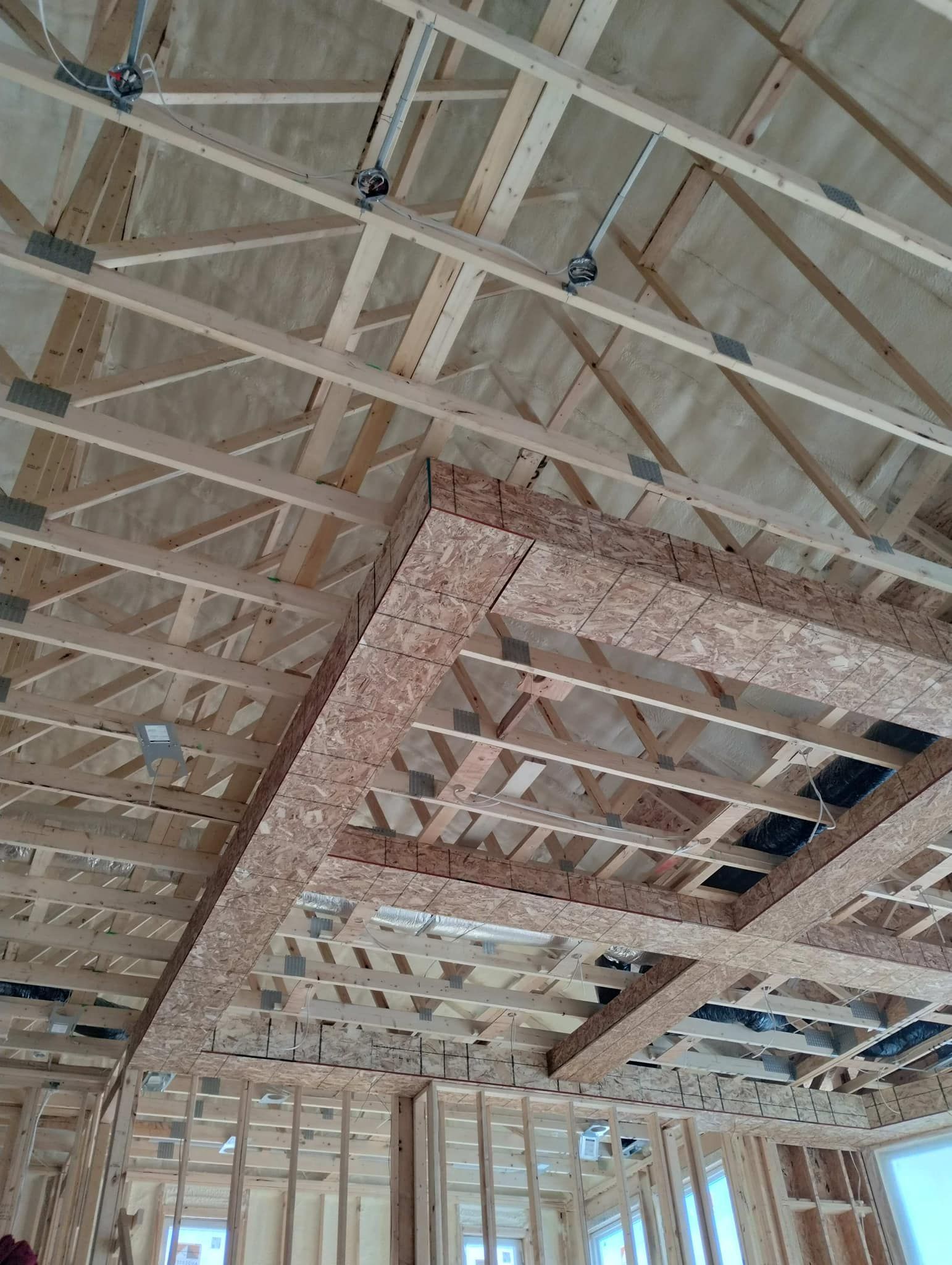 The ceiling of a building under construction with a lot of wooden beams.