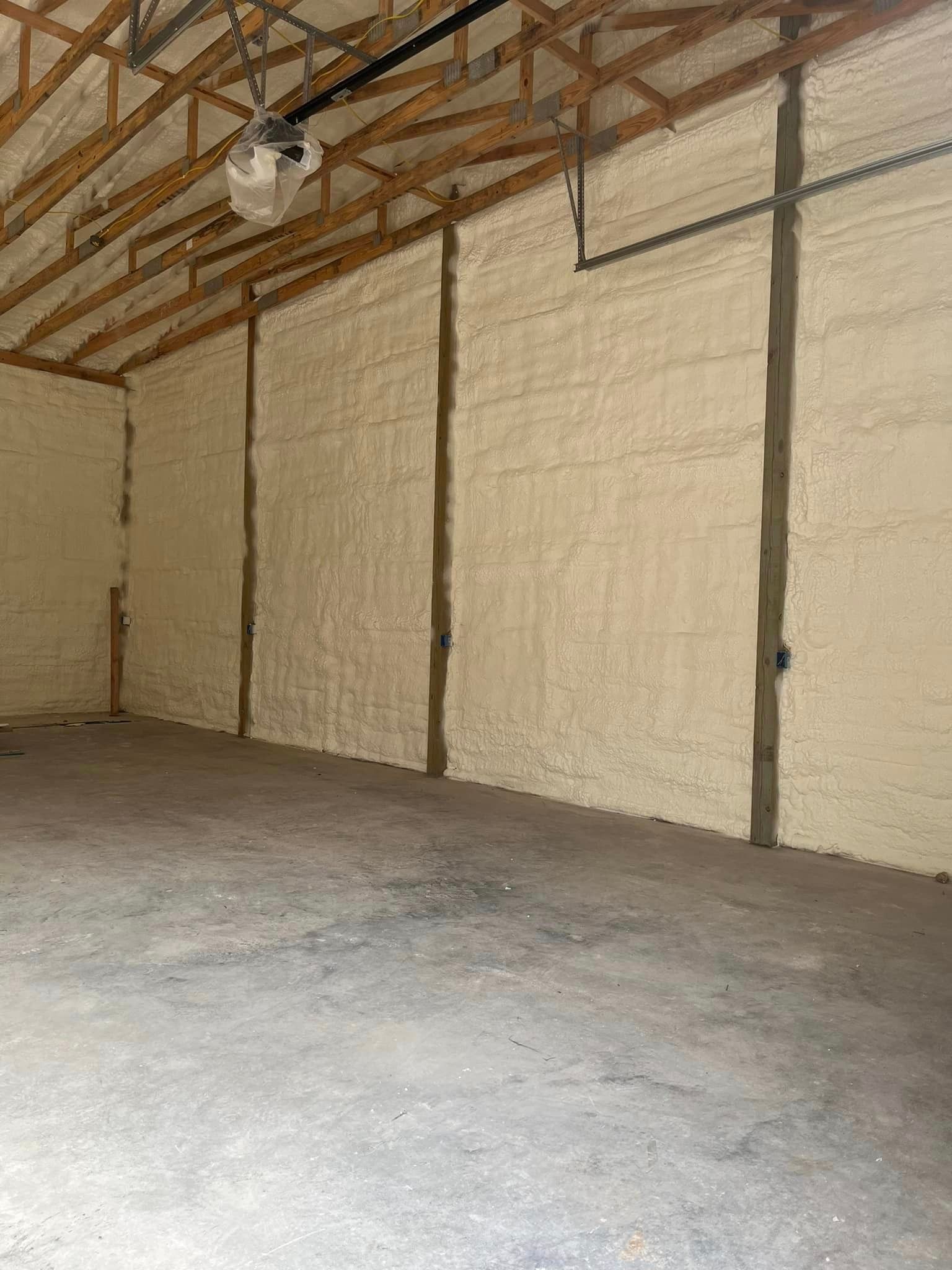 An empty garage with foam insulation on the walls and ceiling.