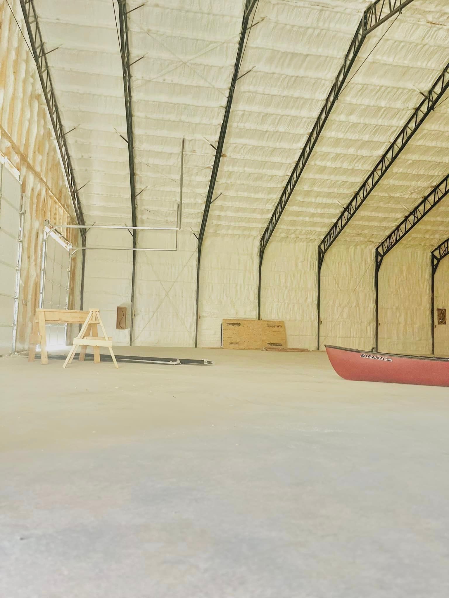 An empty warehouse with a canoe in the middle of it.