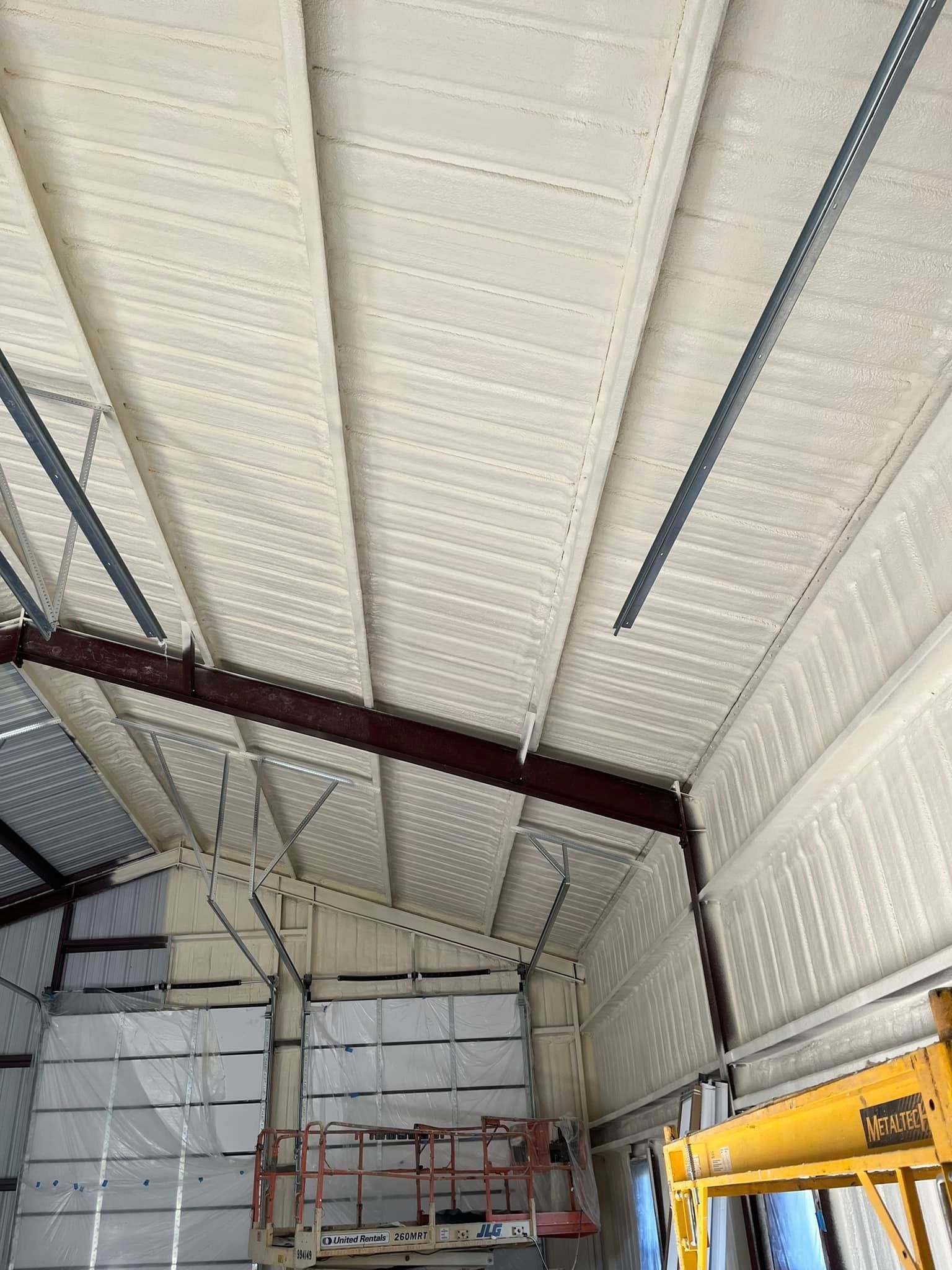 A large building with a ceiling that is being painted white.