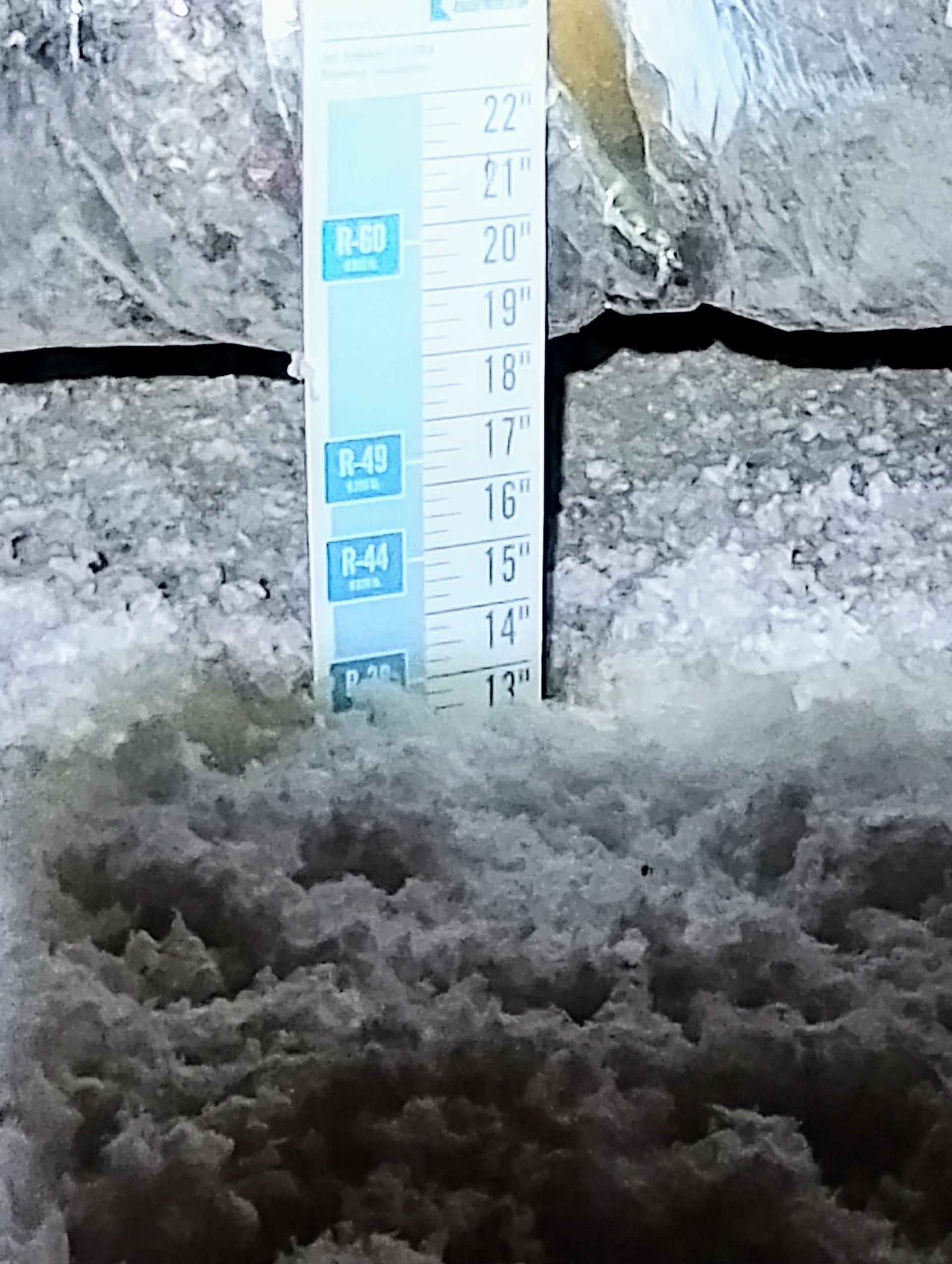 A measuring tape is sitting on top of a pile of insulation.