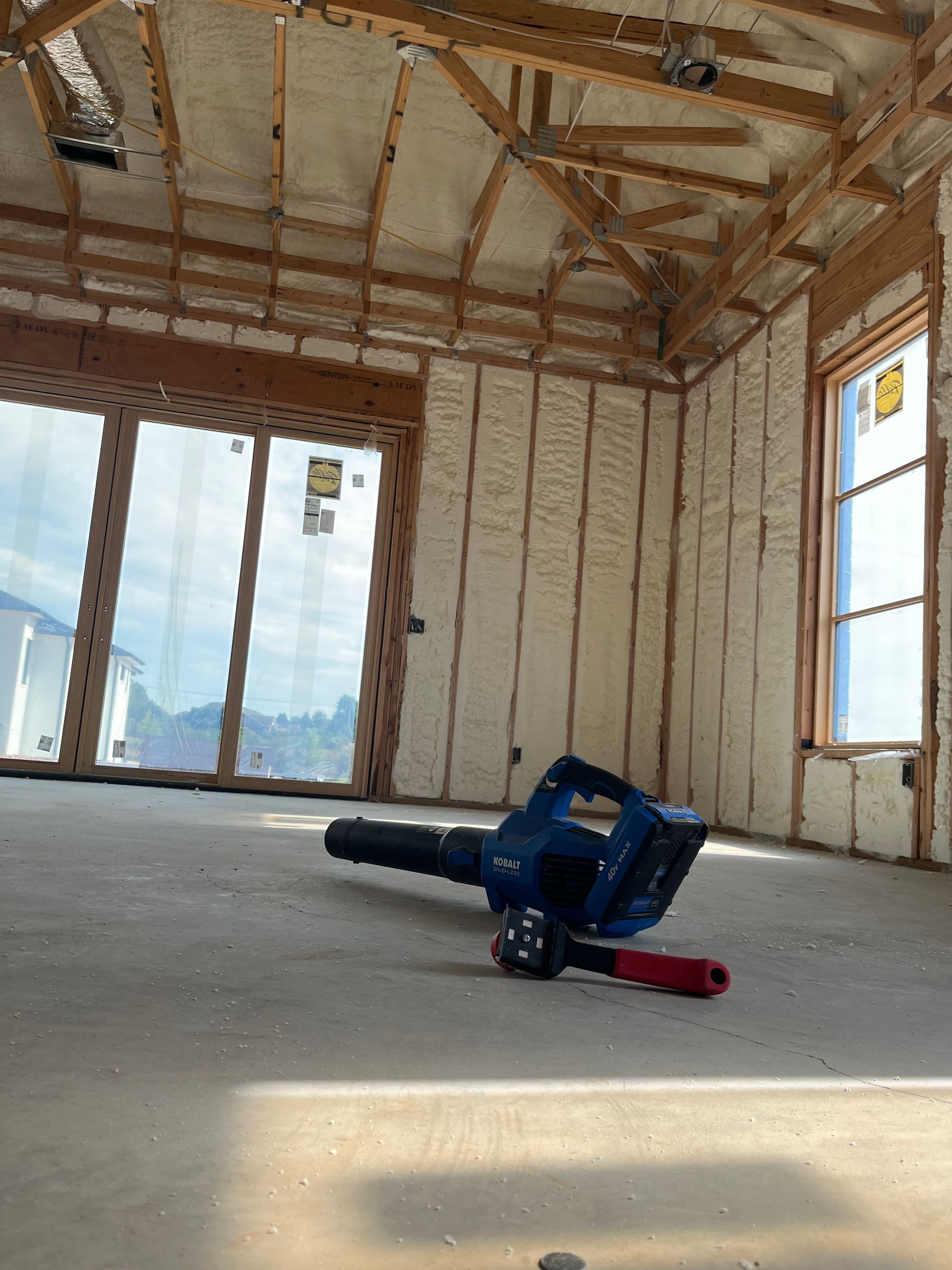 A blower is laying on the floor in an empty room.