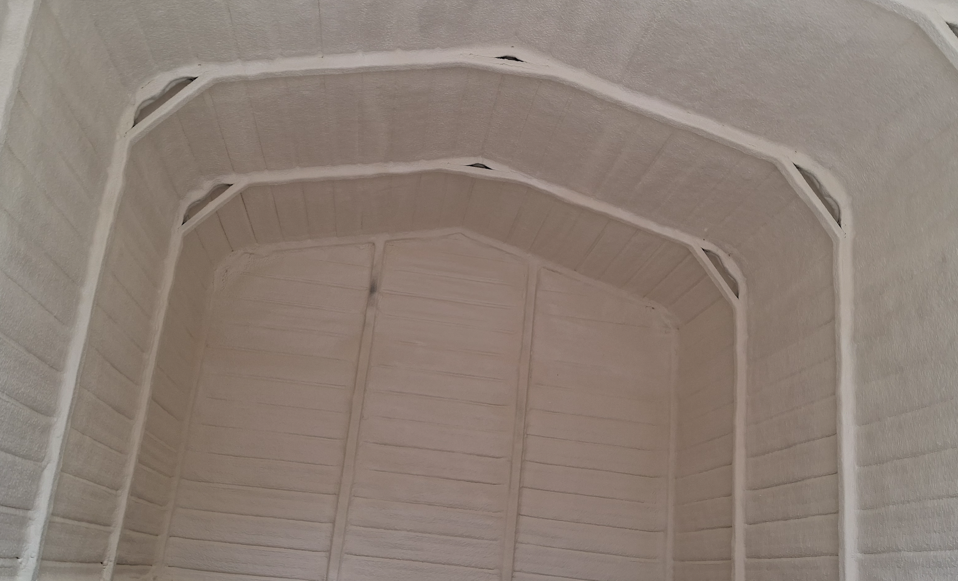 The inside of a white shed with a white roof.